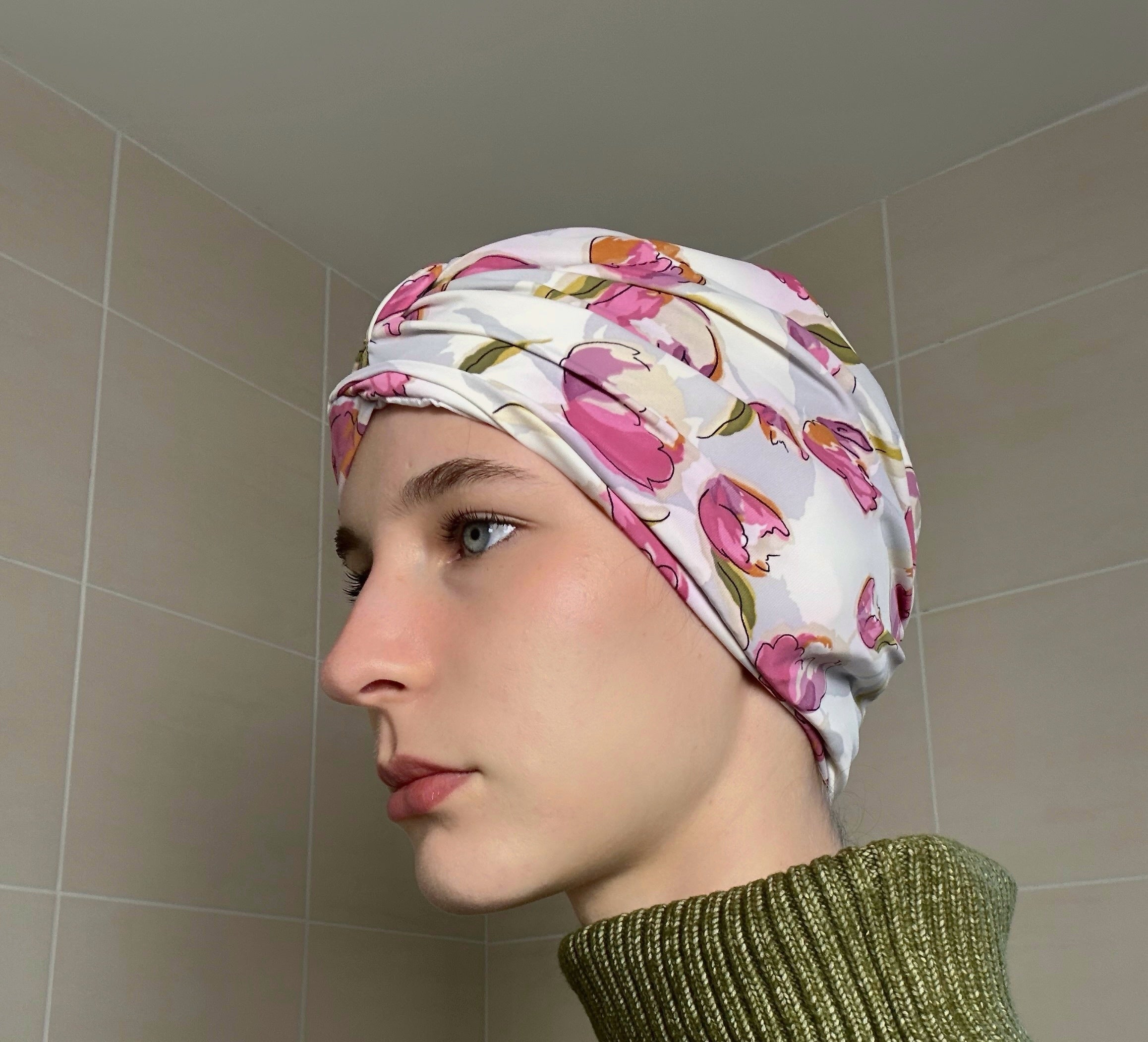 Woman wearing a tulip print shower cap in a bathroom setting
