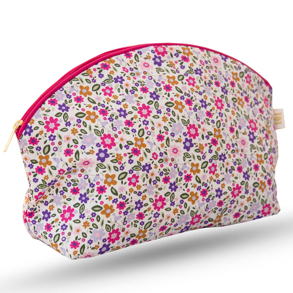 Curved zip top cotton sponge bag. Small pink, green and purple flower print with cerise trim and matching cerise zip.