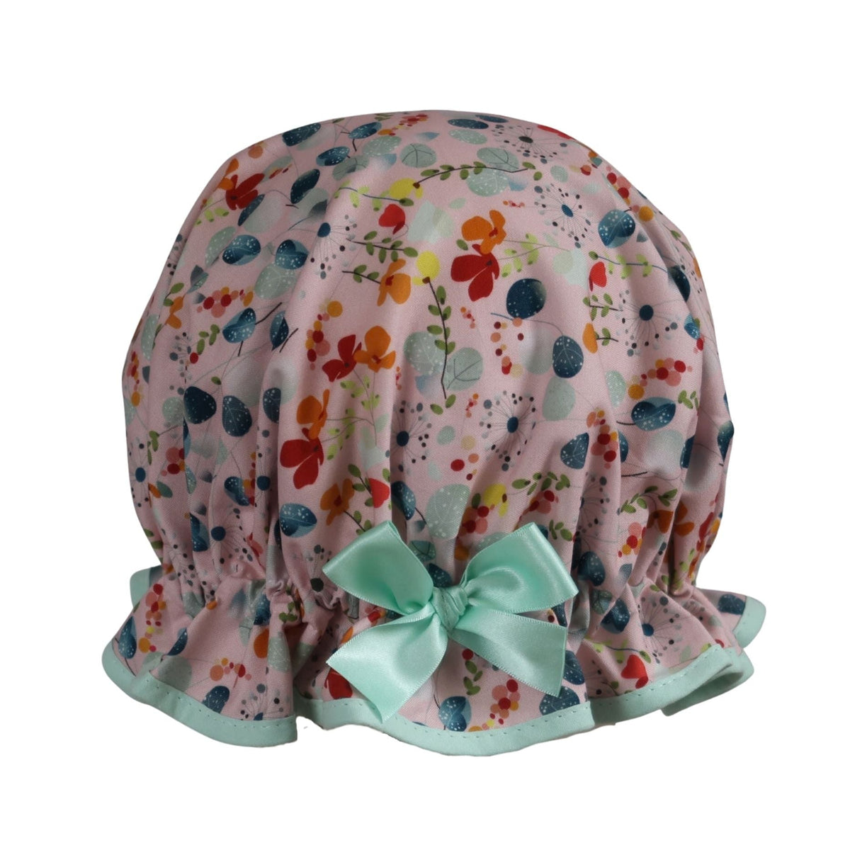 Vintage style women's roomy cotton shower cap.  Frilled edge, grey blue eucalyptus, dandelions, orange and red flowers on a pink background. Trimmed in mint with complementary aqua bow.