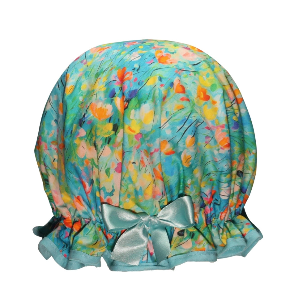 Vintage stlye women's roomy cotton shower cap.  Frilled edge, floral print hat featuring orange, pink, yellow and blue flowers on a fresh blue background.  Trimmed in an aqua blue with matching satin bow.
