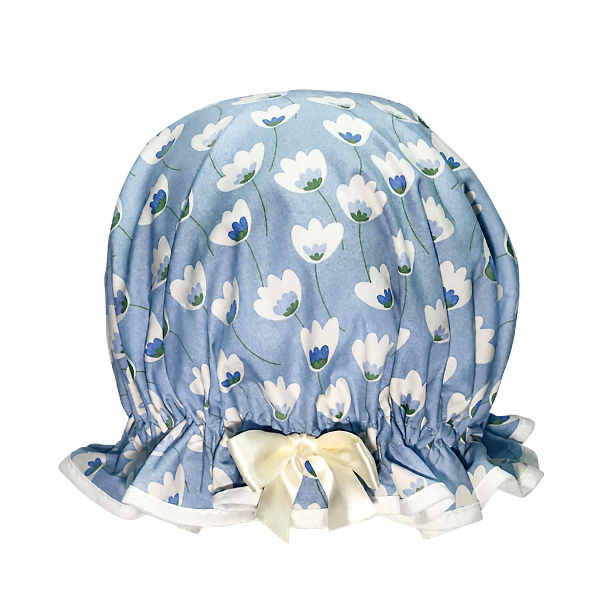 Vintage style women's roomy cotton shower cap.  Frilled edge featuring cream tulip style flowers on a grey blue background.  Trimmed in cream with matching satin bow.