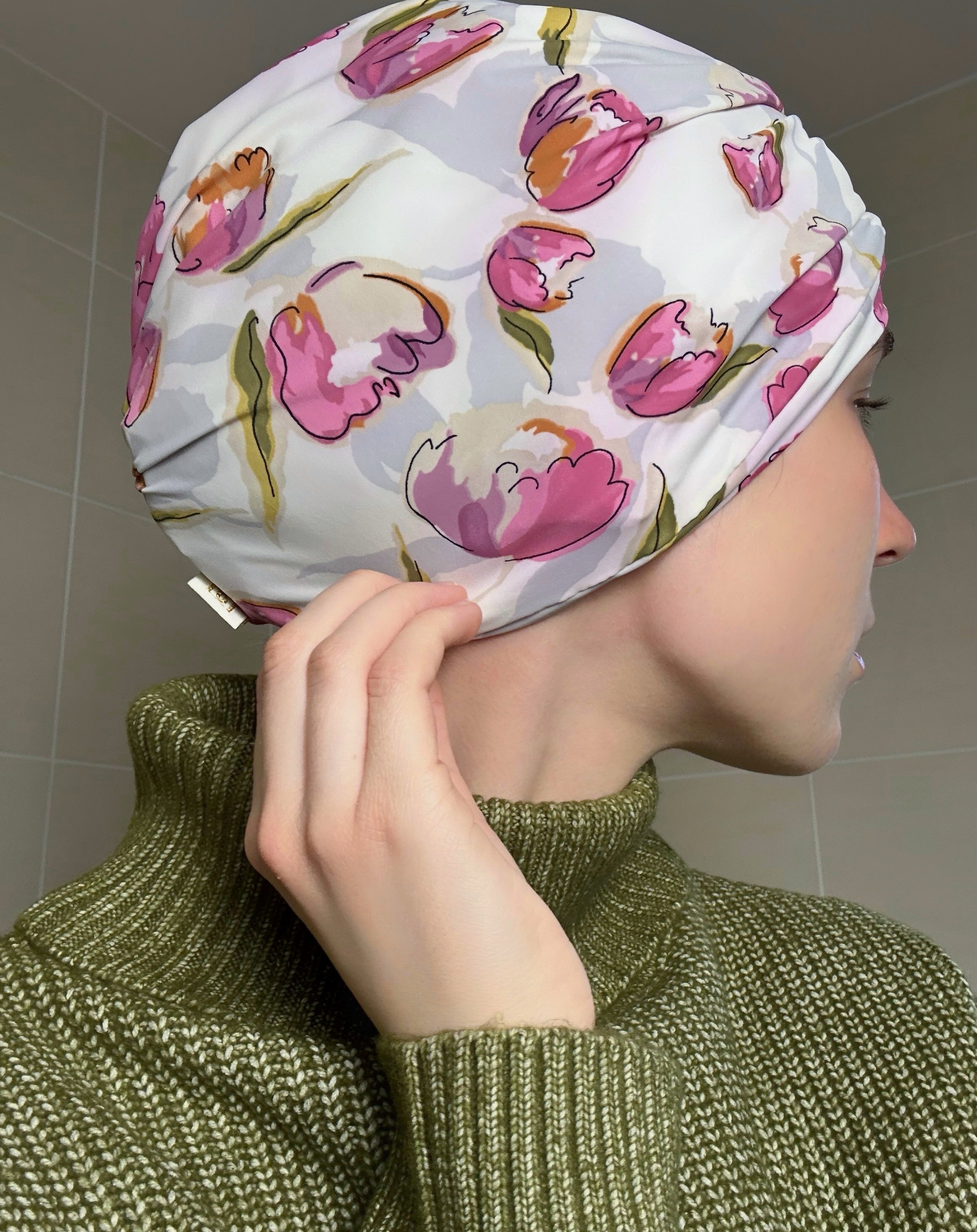 Woman wearing a tulip patterned drying turban with a neutral background