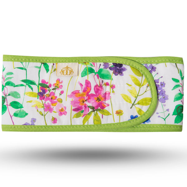 Multicoloured meadow print cotton hairband in blue, pink and purple on a white background.  White microfibre lining and velcro closure strip.