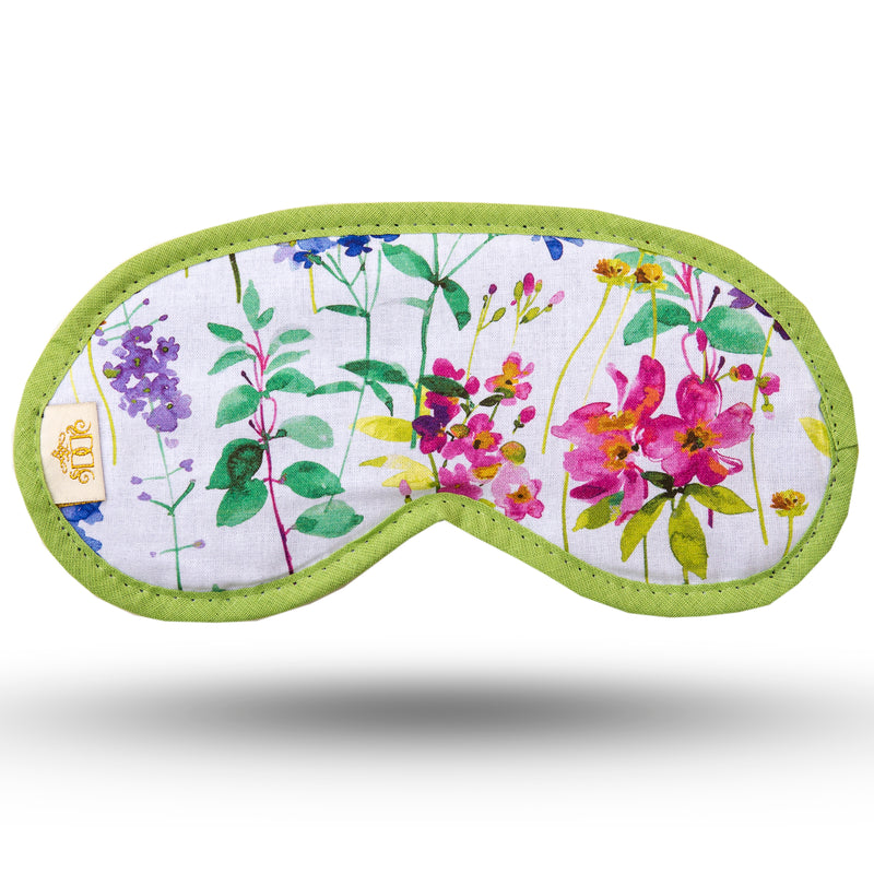 Multicoloured meadow print in blue, pink and purple on a white background sleep mask.  Navy velour backing and elastic.  Edged in green.