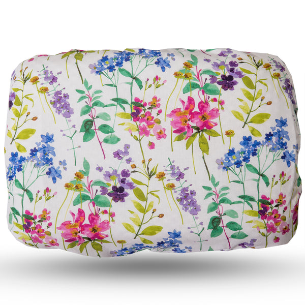 Soft waterproof rectangular bath pillow covered in a multicoloured meadow print in blue, pink and purple on a white background. Suckers on reverse.