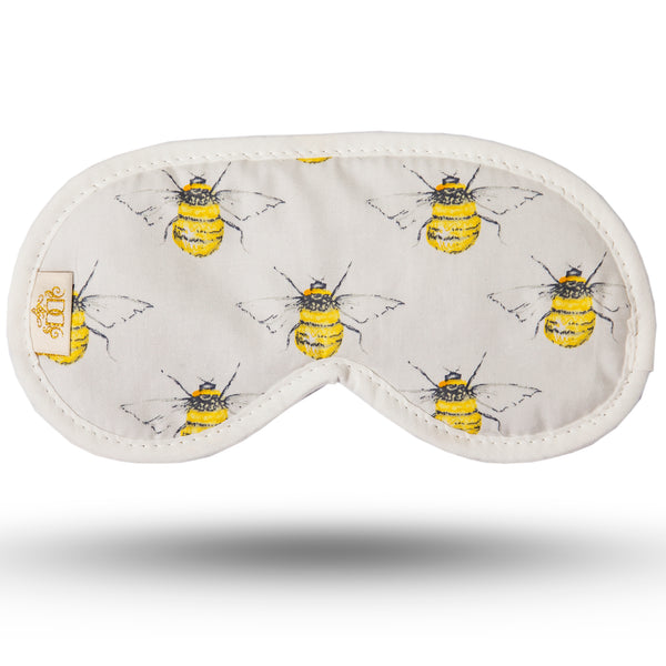 Symmetric bee print on ivory background cotton print sleep mask. Black velour backing and elastic. Edged in with ivory cotton trim.