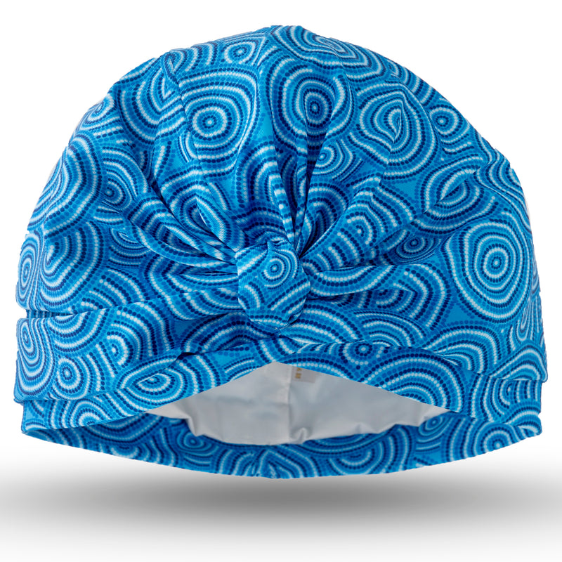 Dark and pale blue circular lycra print pull on waterproof turban, with pretty gather and knotted at front.