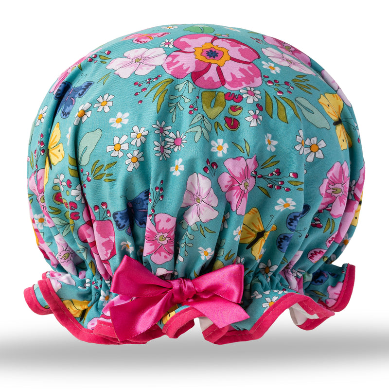 Vintage style women's large cotton shower cap.  Frilled edge, vibrant colourful pink flowers and blue and yellow butterfly print, on a blue background with complementary pink trim and matching satin bow.