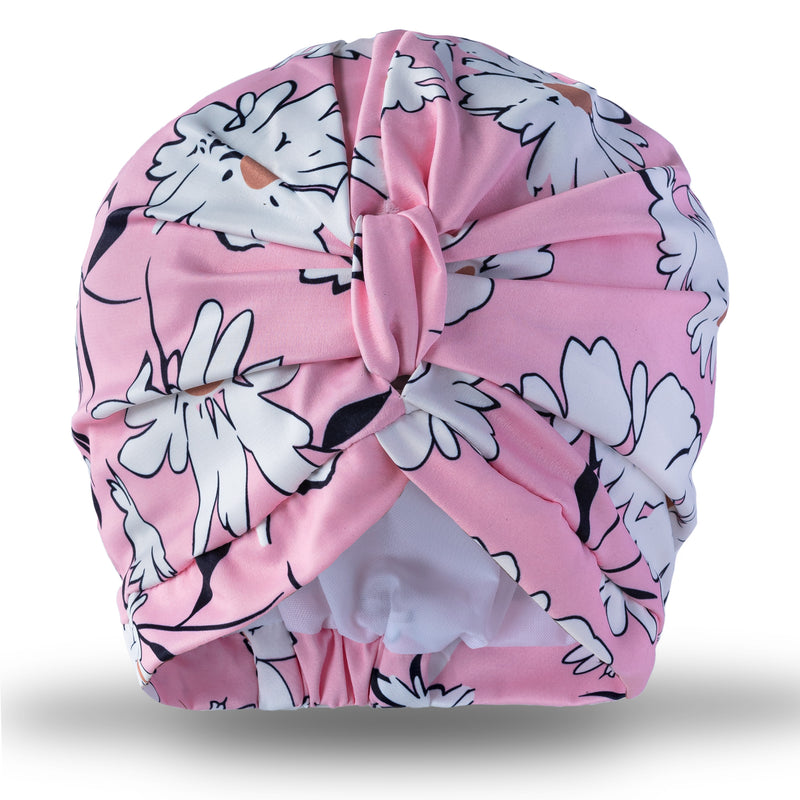 White flowers, edged in black on a delicate pink backround print pull on waterproof turban, with pretty gathered knot at front.