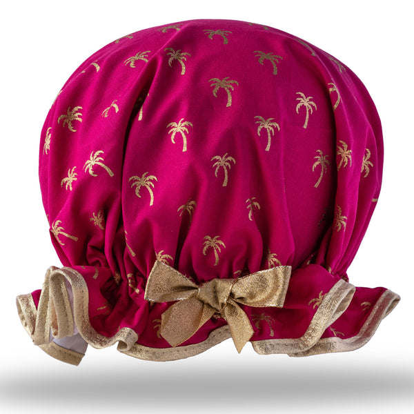Vintage style women's large cotton shower cap.  Frilled edge, gold palm tree print on warm rich pink background, with gold lurex trim and bow.