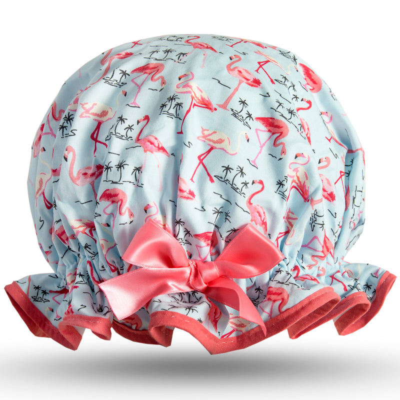 Vintage style women's large cotton shower cap.  Frilled edge, pink flamingos with small black palm tree outline on pale blue background.  Coral trim and satin bow.