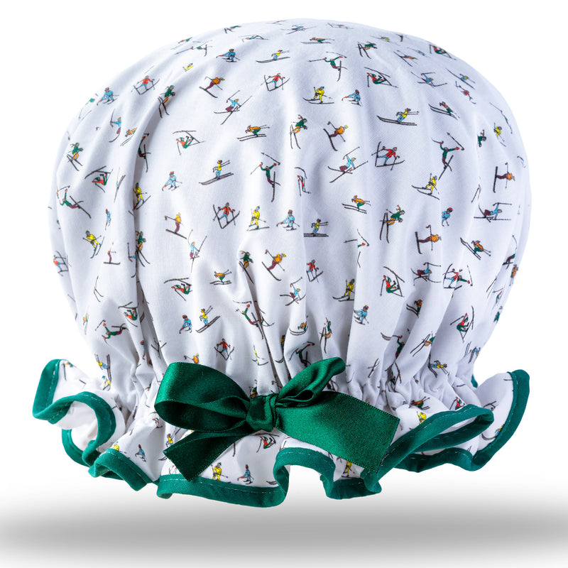 Vintage style, women's large cotton shower cap.  Frilled edge, multicoloured mini ski jumpers print on white background. Trimmed in deep green with matching satin bow.