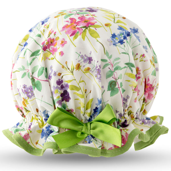 Vintage style, women’s large cotton shower cap. Frilled edge, multicoloured meadow print in blue, pink and purple on a white background.  Trimmed in pale green with matching satin bow.