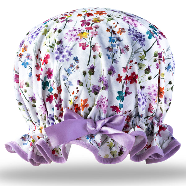 Vintage style, women’s large cotton shower cap. Frilled edge, multicoloured meadow print in blue, pink and purple on a white background.  Trimmed in lilac with matching satin bow.